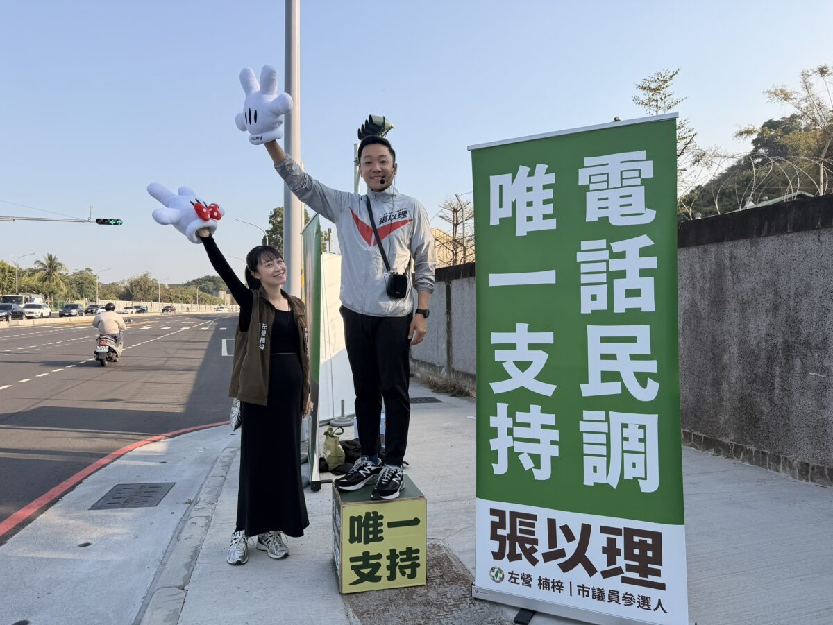 ▲張以理與妻子站上左營、楠梓路口向來往民眾揮手問候，手戴象徵米奇米妮的可愛手套吸引目光，以溫馨互動傳遞親和形象，也為即將登場的電話民調暖身。