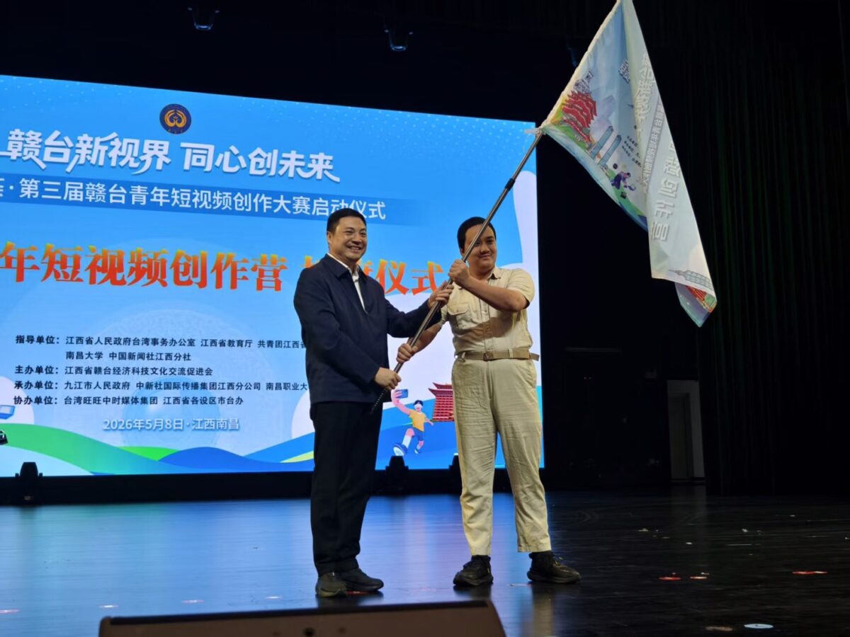▲江西省台辦主任蔡清平(左)為首批參加“贛台青年短視頻創作營”臺灣青年代表授旗。(照片記者徐迪拍攝)