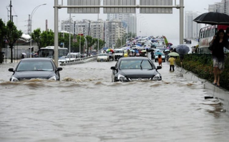 ▲端午首日武漢普降特大暴雨,城市道路大面積積水,車輛涉水難行,市民徒步蹚水出行。