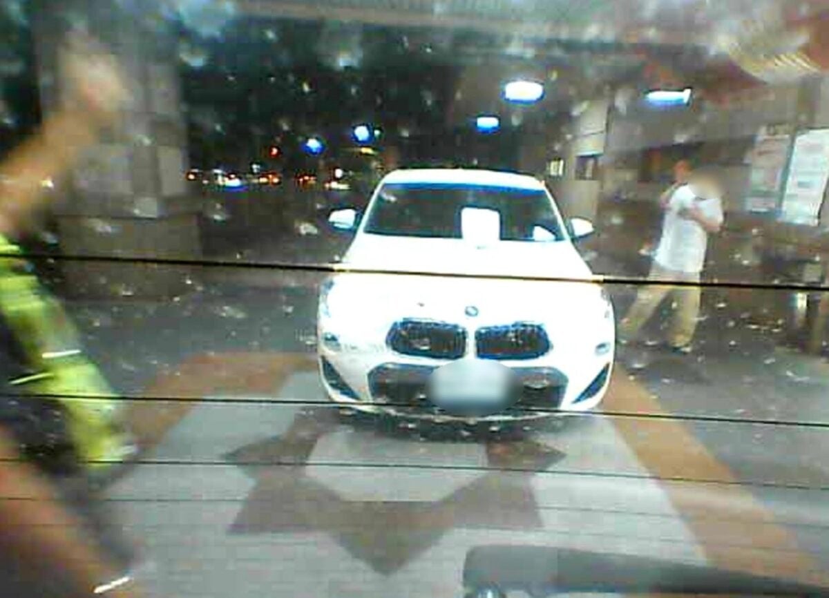 ▲男子下車走向輪椅時,雖一手摀著心臟,神情看起來相當痛苦,仍不忘伸手向警方致意。